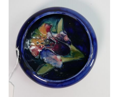 Moorcroft trinket dish in the Orchid pattern: 11cm diameter. Impressed and signed in blue.  Potters to the Queen label. 