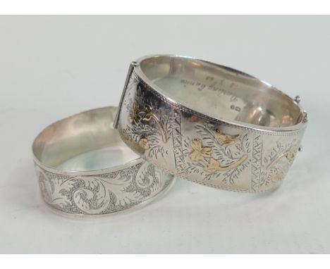 Two silver hallmarked bangles: The larger is Chester hallmarked for 1930, and with gold or gilt embellishments, and engraved 