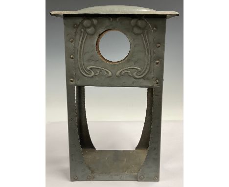 An Art Nouveau domed pewter clock case, the vacant aperture flanked by a pair of stylised sinuous stems, planished lightly th