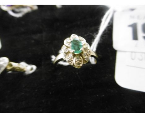 A YELLOW METAL EMERALD AND DIAMOND RING MARKED 750, SIZE M