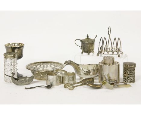 A silver tea caddy, three napkin rings, a heart shaped toast rack, a shovel, a pair of tongs, a pepperette, a pierced dish an