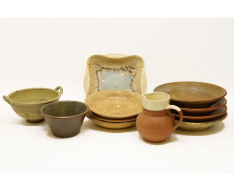 A large quantity of pottery kitchen wares, to include milk pans, a strainer, a bread crock, etc