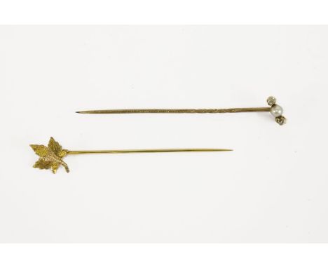 A gold three stone pearl and diamond stick pin in case, and a gold maple leaf stick pin, leaf marked 14k, box by Henry Birkis