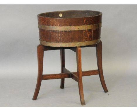 An oak oval planter on stand, labelled 'R A Lister', 50cm