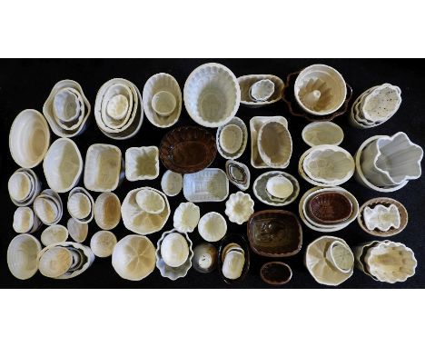 A large quantity of pottery unnamed jelly moulds, to include a mould in the form of a girl sat on a bench with a dog under he