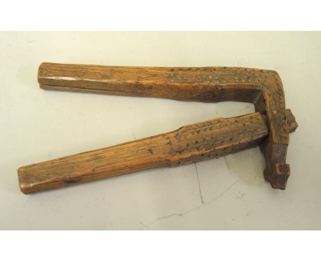 Early Treen Ware lever action nutcracker with primitive carved decoration, 15cm long 