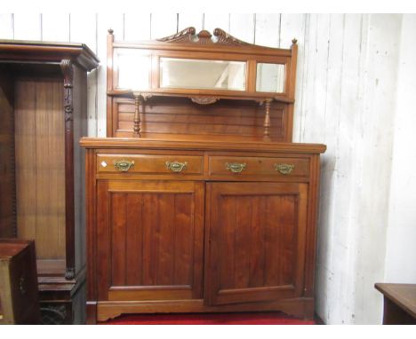 Late 19th Century walnut chiffonier, the bevelled mirror and shelf back above two drawers and two panel doors enclosing shelv