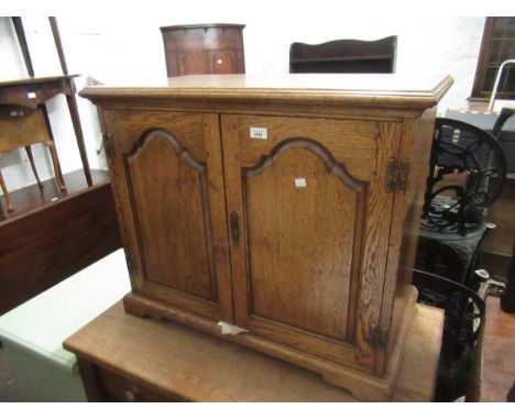 Good quality reproduction oak side cabinet with two fielded panel doors enclosing a fitted interior, 84cm wide 