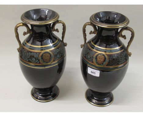 Pair of late 19th / early 20th Century black glazed terracotta two handled baluster form vases decorated with a classical por