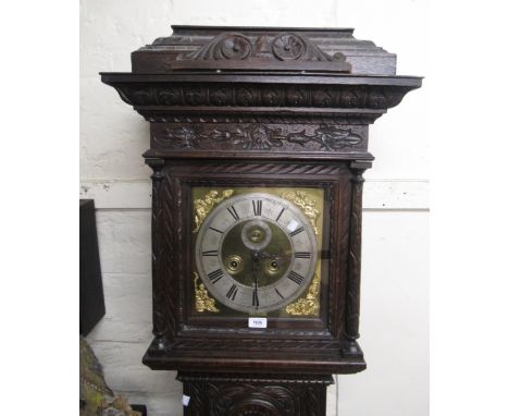 Oak longcase clock, the later carved case with a square hood above an arched panel door and reduced conforming plinth, the br