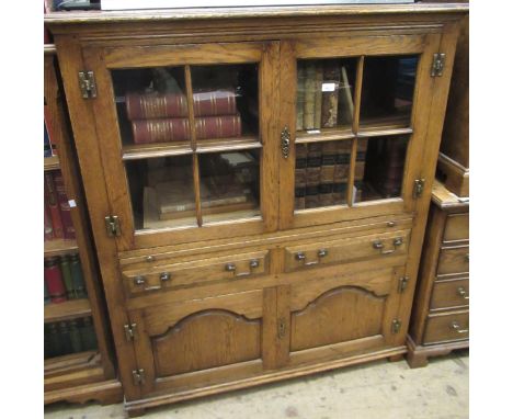 Good quality reproduction oak side cabinet with a pair of bar glazed doors above a pull-out slide, two drawers and two fielde