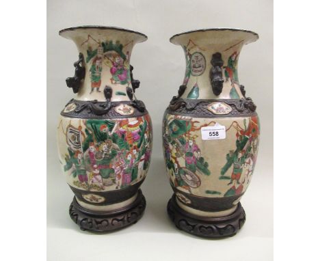 Pair of 19th Century Chinese crackleware enamel decorated vases, decorated with various figures on hardwood stands, 37cm high