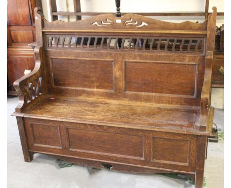 Arts and Crafts oak hall bench, the pierced and panelled back above a box seat and panel base with stile supports, 153cm wide