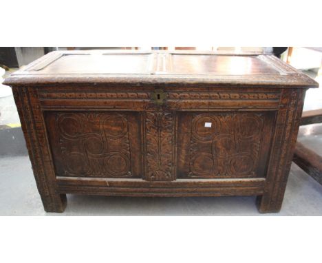 17th Century oak coffer, the hinged two panel lid above a carved two panel front on stile supports, 106cm wide 
