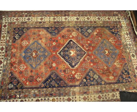 Qashqai carpet with a triple medallion and all-over stylised flowerhead design on a red ground with borders, 300 x 200cm appr