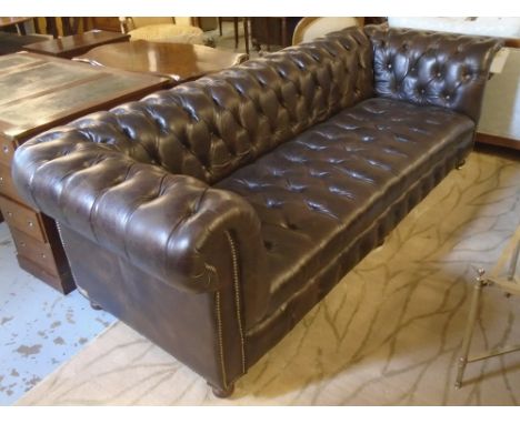 CHESTERFIELD SOFA, in a burnt Umber leather, on bun feet with castors, approx. 238cm x 92cm x 75cm.