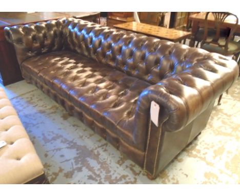 CHESTERFIELD SOFA, in a burnt Umber leather, on bun feet with castors, approx. 238cm x 92cm x 75cm.