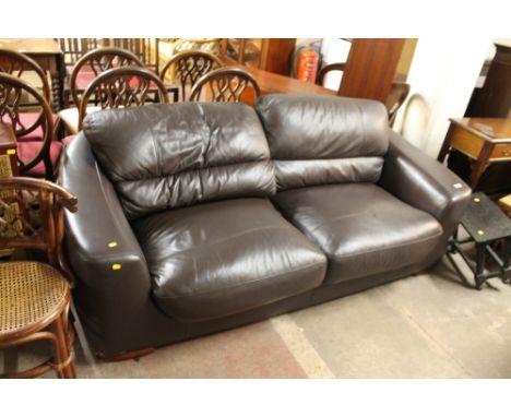 A BLACK FAUX LEATHER TWO SEATER SOFA 