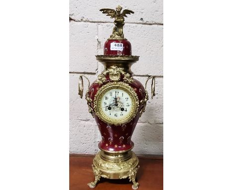 Red porcelain and fleur de lys design Mantle Clock, with a gilt Phoenix Mount, chimes on a bell, the dial painted with figure