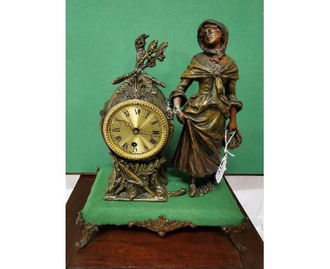 Mantel Clock, featuring Spelter figure of lady wearing a cape, brass dial, raised on cabriole leg stand, 38 x 30cm