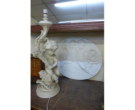 A cherub table lamp and oval cherub wall plaque