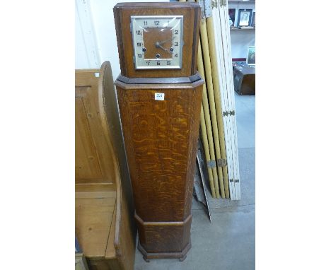 An oak mantel clock on pedestal