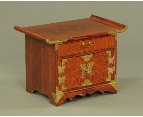 A Chinese tabletop cabinet, fitted with a drawer and pair of panelled cupboard doors with brass hinges and fittings and all r