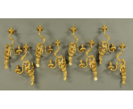 A set of eight Ormolu two branch wall light fittings, decorated with mythical creatures and figural masks.  Height 56 cm, wid