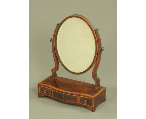 A 19th century mahogany dressing table mirror, oval with bevelled glass, the serpentine base fitted with three drawers and ra