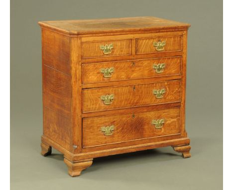 A George III oak chest of drawers with canted front corners, fitted two short and three long drawers on ogee bracket feet.  9