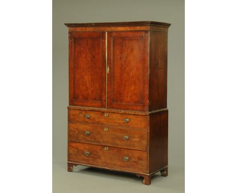 A George III mahogany linen press, with detachable moulded cornice above a pair of panelled doors opening to hanging space, t