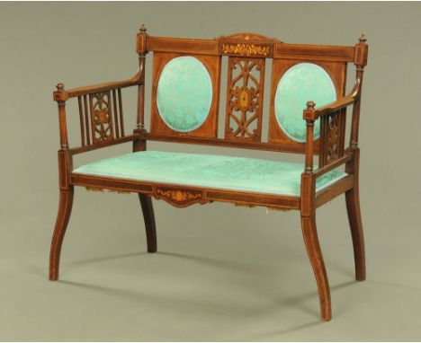 An Edwardian inlaid mahogany two seat salon settee with pierced back and sides, the back and seat upholstered in pale green c