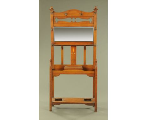 An Edwardian walnut hall stand of Art Nouveau Design, inset with rectangular bevelled mirror, fitted with eight copper hooks 