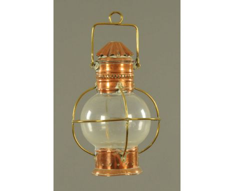A Victorian copper and brass mounted tilly lamp, with spherical clear glass shade.  36 cm high, lacking burner and wick.