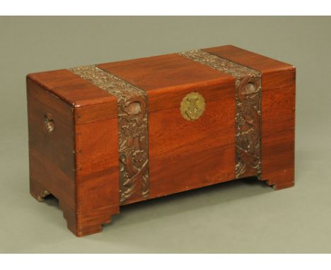 A Chinese carved camphorwood trunk, with carved bands and raised on stepped feet.  Width 100 cm, height 53 cm, depth 50 cm.