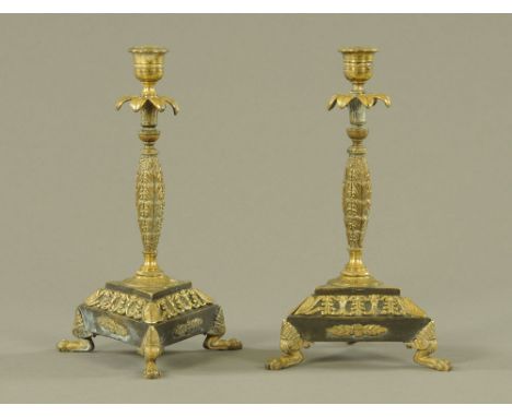 A pair of Regency brass candlesticks, with triform bases and raised on three paw feet.  Height 25 cm (see illustration). COND