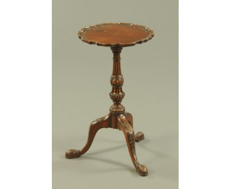 A mahogany wine table, Chippendale style with pie crust edge carved column and three downswept legs terminating in pad feet. 