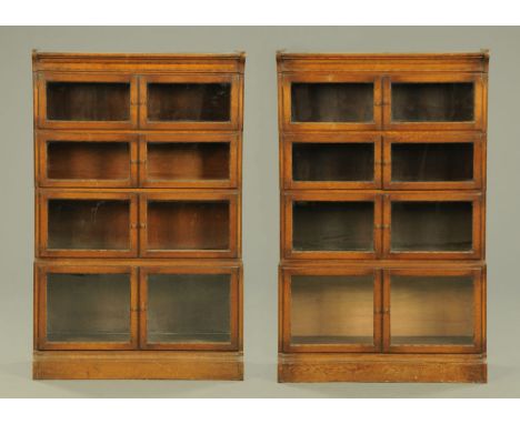 A pair of 1930's oak four tier sectional bookcases, with bobbin mouldings each tier with a pair of doors.  141 cm high, 89 cm