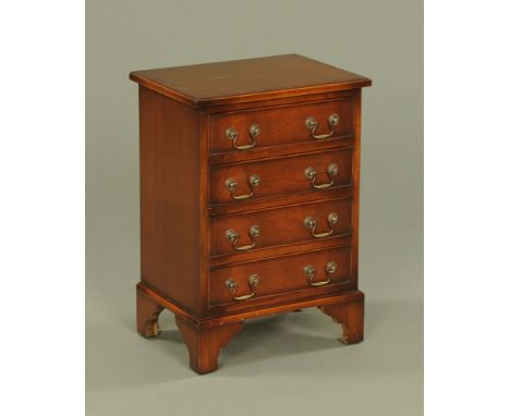 A small reproduction mahogany chest of four long graduated drawers, with brass drop handles and raised on bracket feet.  Heig