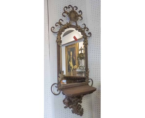 METAL SWIRLED WALL MIRROR, with a bevelled plate, gilt detail and shelf, 107cm H x 44cm W.