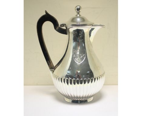 A late Victorian silver hotwater jug, by Thomas Bradbury, London 1900, of baluster shape, the lower body fluted, the hinged c