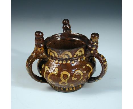 A Wrotham brown and yellow slip ware tyg/ puzzle jug, dated 1689 between the spire topped handles, and with 'I.I' for John If