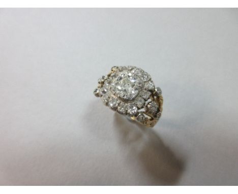 An early 19th century diamond ring, with an old mine cut diamond in a double border of smaller similar and old cushion cut di