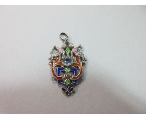 An Austro-Hungarian enamel and gem set pendant, set to the centre with an oval cut light blue sapphire in a pierced foliate a
