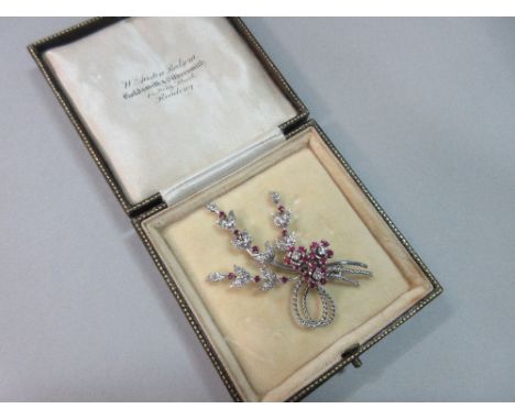 A ruby and diamond flower spray brooch, the three flowers with round brilliant cut diamond centres and round cut ruby petals 
