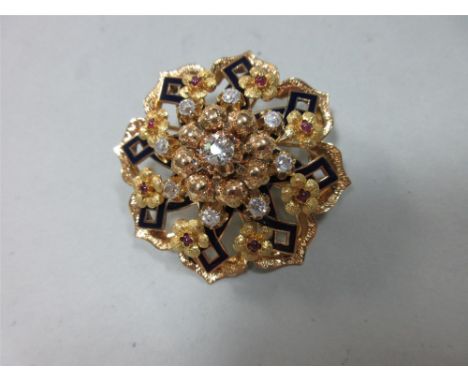 A diamond, ruby and enamel circular brooch, designed as a pierced flowerhead centred on an old round brilliant cut diamond wi