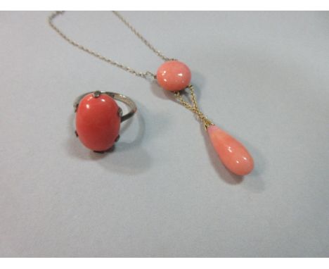 A red coral single stone ring and a simulated coral pendant necklace, the oval cabochon natural colour coral, 1.8cm long, six