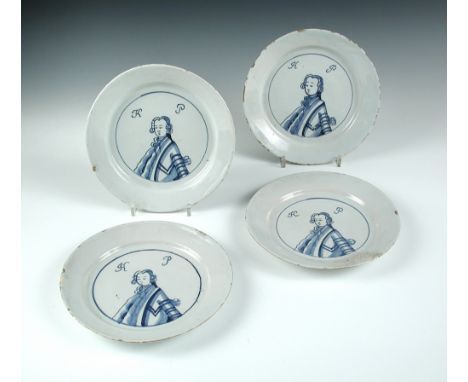 Four mid-18th century English Delft blue and white 'King of Prussia' plates, each painted with a central portrait bust below 