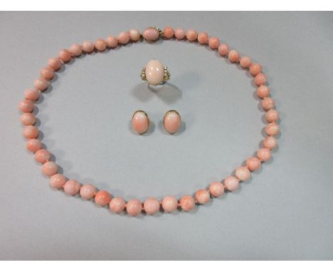 A Neopolitan 'angel skin' coral suite of bead necklace and earstuds with matched coral and diamond ring, the slightly graduat