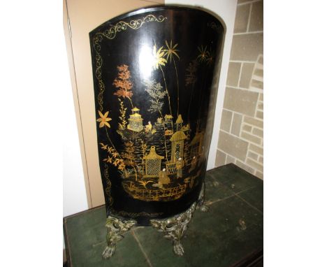 A 19th century black tole chinoiserie fireguard, the rounded front of the round arch panel above three foliate topped paw fee